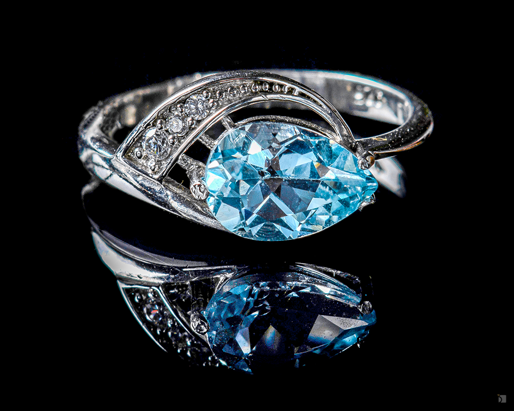 Isolated Restored Fine Jewelry Blue Topaz Gemstone Diamond Ring Reflected Against Black Background