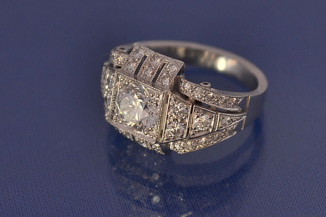 Image showcasing diamond art-deco style ring on blue surface