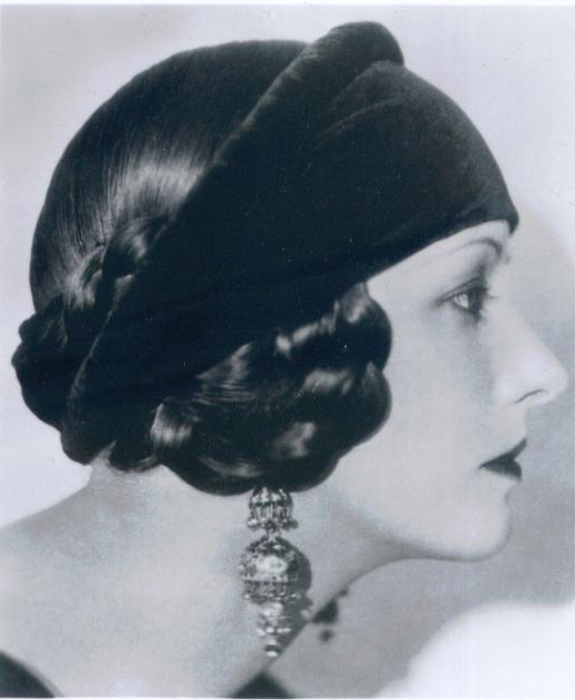Image showcasing American costume designer Natacha Rambova wearing headpiece and drop earrrings Circa 1920 in black and white