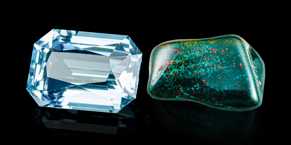 Combined Cut and Polished Aquamarine Bloodstone Gemstones Reflected Against Black Background