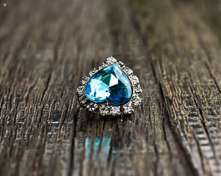 Restored Heart-Shaped Aquamarine and Diamond Gemstone Jewelry Piece On Wooden Platform