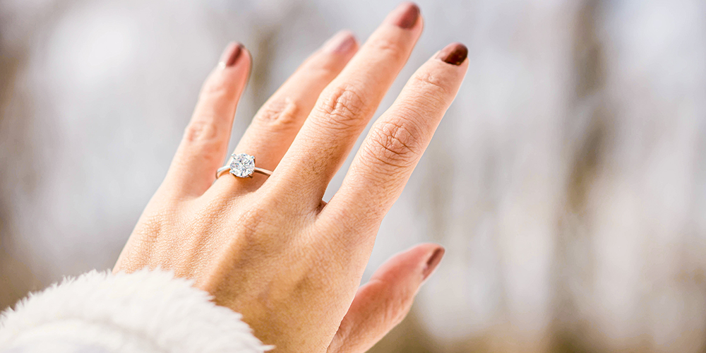 Hand Displaying Diamond Engagement Ring