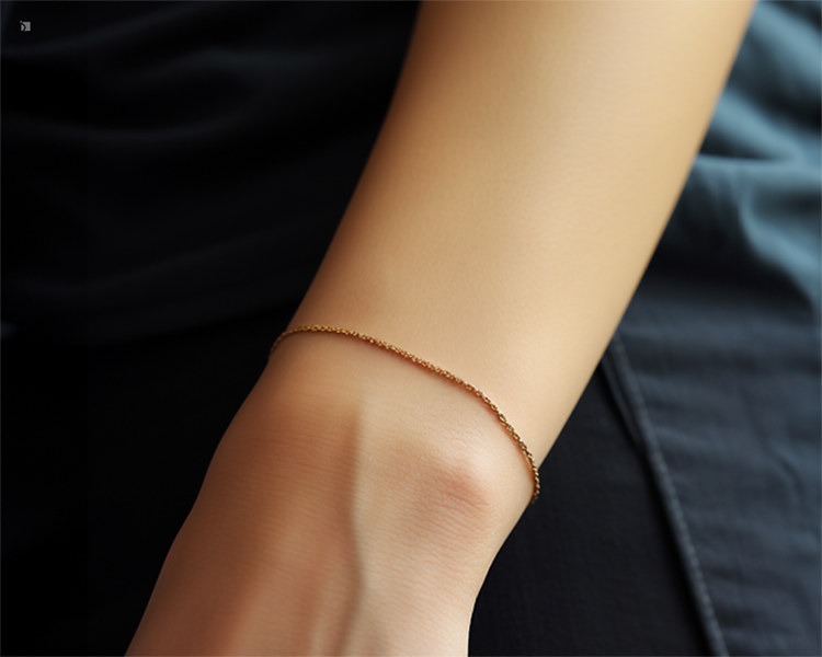 Dainty Gold Bracelet Permanently Welded Jewelry Onto Person's Wrist Against Black Fabric